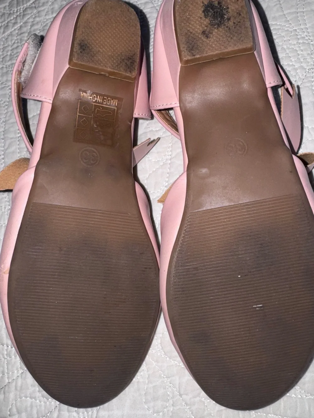 These pastel pink Mary Janes feature a delicate crisscross ankle strap adorned w